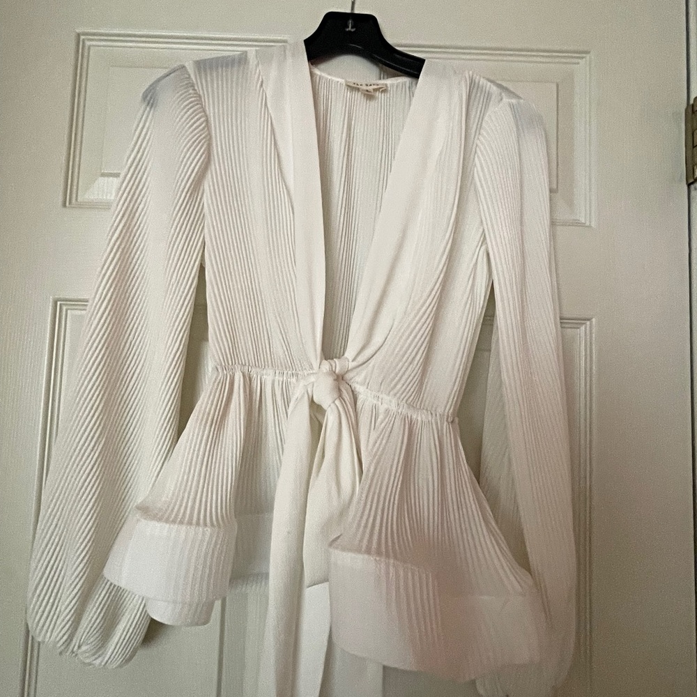 Off white top,tie front with elastic on wrists.Deep v-front.Never been worn.